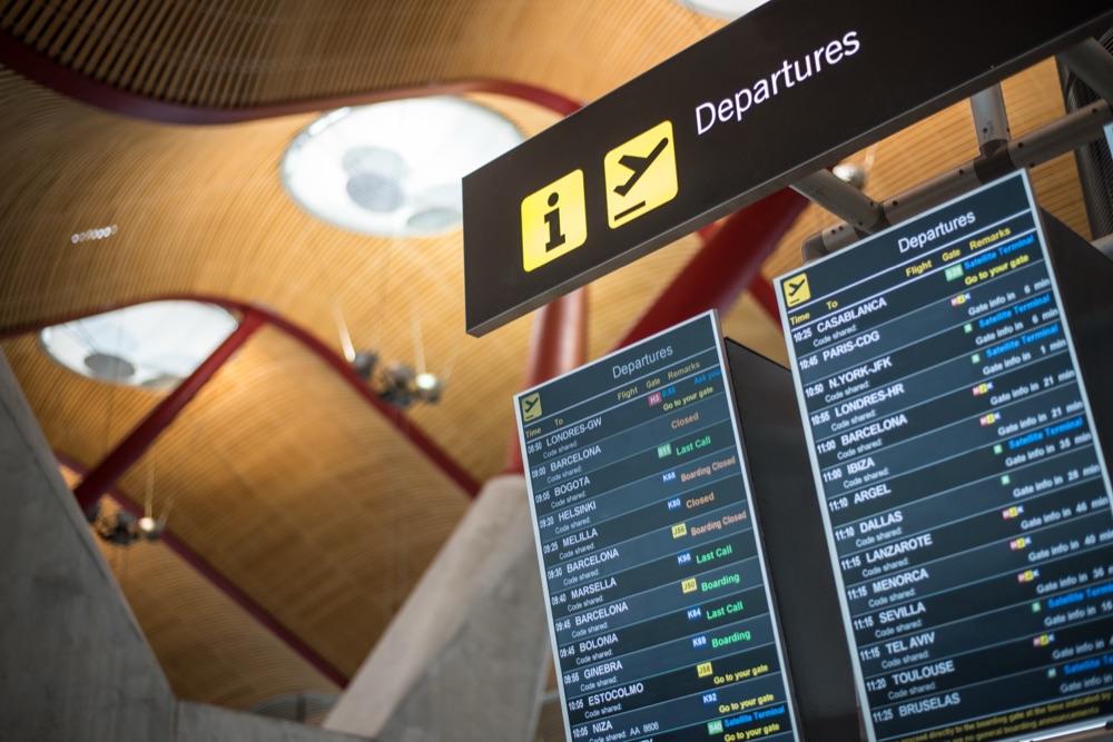 Airport departures board showing flight times, the kind families check before a pre-booked taxi transfer with a child seat